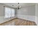 Cozy dining room featuring hardwood floors, chandelier, wainscoting, and natural light at 2355 Glen Chase Ln, Lawrenceville, GA 30044