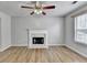 Cozy living room featuring a fireplace, ceiling fan, and stylish flooring at 2355 Glen Chase Ln, Lawrenceville, GA 30044