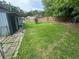 Spacious backyard featuring green grass, a chain-link fence, and a small storage unit at 3730 Clovis Nw Ct, Atlanta, GA 30331