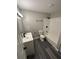 Bright bathroom featuring a white vanity, subway tile shower, and gray wood-look flooring at 3730 Clovis Nw Ct, Atlanta, GA 30331