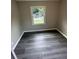 Bedroom features gray walls, one window with natural light, and gray wood-look flooring at 3730 Clovis Nw Ct, Atlanta, GA 30331