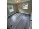 Bright bedroom featuring gray wood-look flooring and natural light from two windows at 3730 Clovis Nw Ct, Atlanta, GA 30331