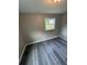 Bright bedroom featuring sleek gray floors and a window, complemented by neutral walls and modern lighting at 3730 Clovis Nw Ct, Atlanta, GA 30331