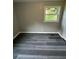 Neutral bedroom features gray walls, gray wood-look flooring, and natural light from a window at 3730 Clovis Nw Ct, Atlanta, GA 30331