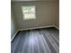 This cozy bedroom offers sleek gray floors and natural light through a window, a perfect retreat at 3730 Clovis Nw Ct, Atlanta, GA 30331