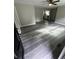 Open-concept living room with new grey flooring, ceiling fan, and a view of the kitchen at 3730 Clovis Nw Ct, Atlanta, GA 30331