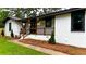 Charming home with a freshly painted white brick exterior, manicured lawn, and inviting front porch at 4296 Langdon Dr, Decatur, GA 30035
