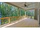 Wide, covered, back porch with wood railings and a ceiling fan overlooking wooded backyard at 85 Presley Farm Pkwy, Rockmart, GA 30153