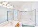 Bright bathroom featuring a large soaking tub, tile flooring, and tiled walls at 2759 Bay Ridge Dr, Loganville, GA 30052