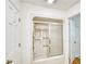 Bathroom featuring a shower-tub combo with sliding glass doors and a clean, white design at 2759 Bay Ridge Dr, Loganville, GA 30052