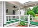 Charming front porch with green carpet, white railings, and meticulous landscaping at 2759 Bay Ridge Dr, Loganville, GA 30052