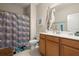 Colorful bathroom featuring a vanity with wood cabinets, framed mirror, and a shower with an eye-catching curtain at 2797 Middlecreek Way, Cumming, GA 30041