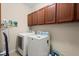 Functional laundry room with overhead cabinetry, a washing machine, and a dryer at 2797 Middlecreek Way, Cumming, GA 30041