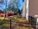 Fenced backyard featuring a lush lawn, mature trees, and blooming bushes at 505 Tilbury Dr, Suwanee, GA 30024