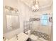 Bathroom featuring a glass door shower, designer tile, chrome fixtures, and ample lighting at 505 Tilbury Dr, Suwanee, GA 30024