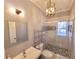 Updated bathroom with tiled shower, decorative tile accents, vanity, and modern lighting at 505 Tilbury Dr, Suwanee, GA 30024