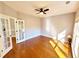 Bright bedroom with hardwood flooring, ceiling fan, and natural light, featuring a door to another room at 505 Tilbury Dr, Suwanee, GA 30024