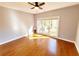 Sun-filled bedroom with hardwood floors, ceiling fan, and large windows offering backyard views at 505 Tilbury Dr, Suwanee, GA 30024