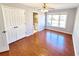A bedroom featuring hardwood floors, a ceiling fan, a large window, and a double-door closet at 505 Tilbury Dr, Suwanee, GA 30024