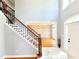 Welcoming foyer with staircase with dark iron accents, hardwood flooring and dining room at 505 Tilbury Dr, Suwanee, GA 30024