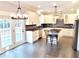 Open kitchen featuring white cabinetry, stainless steel appliances, granite countertops, and stylish pendant lighting at 505 Tilbury Dr, Suwanee, GA 30024