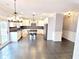 Spacious eat-in kitchen with white cabinets, stainless steel appliances, pendant lighting and a view to the backyard at 505 Tilbury Dr, Suwanee, GA 30024