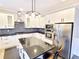 Modern kitchen with stainless steel appliances, custom cabinetry, granite countertops, and island with breakfast bar at 505 Tilbury Dr, Suwanee, GA 30024