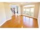 Bright living room featuring hardwood floors and a large arched window with view to foyer at 505 Tilbury Dr, Suwanee, GA 30024