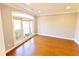 Bright living room featuring hardwood floors and a large arched window with neutral blinds at 505 Tilbury Dr, Suwanee, GA 30024