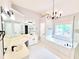 A bathroom with double vanity, a chandelier, a separate shower, and a garden tub at 505 Tilbury Dr, Suwanee, GA 30024