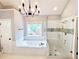 A bathroom with an enclosed walk-in shower, a garden tub, and white subway tile at 505 Tilbury Dr, Suwanee, GA 30024