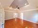 Spacious main bedroom with hardwood floors, tray ceiling, and access to main bathroom at 505 Tilbury Dr, Suwanee, GA 30024