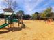 Community playground with slides, climbing structures, and swings on wood chip ground at 505 Tilbury Dr, Suwanee, GA 30024
