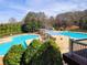 Exterior view of the community pool with lounge chairs and sun shades on a sunny day at 505 Tilbury Dr, Suwanee, GA 30024
