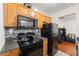 Functional kitchen with black appliances, wood cabinets, and a gray backsplash at 6901 Gallant Se Cir # 13, Mableton, GA 30126