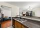Kitchen featuring granite countertops, wood cabinets, stainless steel sink and a view of the living room at 6901 Gallant Se Cir # 13, Mableton, GA 30126