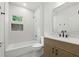 Modern bathroom featuring a tub with shower, stylish vanity, and small window with natural light at 12230 Asbury Park Dr, Roswell, GA 30075