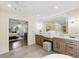 Luxurious bathroom featuring dual vanities, a large mirror, and an adjacent bedroom, creating a spa-like retreat at 12230 Asbury Park Dr, Roswell, GA 30075