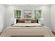 Serene bedroom featuring a plush bed, decorative pillows, and large windows providing ample natural light at 12230 Asbury Park Dr, Roswell, GA 30075