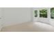 Bright bedroom space featuring neutral carpet, large windows, and fresh white walls, ideal for relaxation at 12230 Asbury Park Dr, Roswell, GA 30075