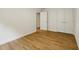 This bedroom features hardwood floors, white walls, and double door closet at 12230 Asbury Park Dr, Roswell, GA 30075