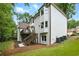 Exterior of a two-story home featuring a deck, staircase, white siding, and a well-maintained lawn at 12230 Asbury Park Dr, Roswell, GA 30075