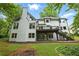 Rear exterior of the home with wood deck and stairs leading to backyard patio at 12230 Asbury Park Dr, Roswell, GA 30075