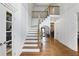 Elegant foyer with hardwood floors, staircase, and a stylish mirror reflecting the kitchen at 12230 Asbury Park Dr, Roswell, GA 30075