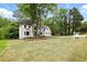 Well-manicured front yard of a two-story home with lush greenery, a spacious lawn, and an inviting entrance at 12230 Asbury Park Dr, Roswell, GA 30075