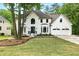 Gorgeous home with green lawn, mature trees, a two-car garage, and beautiful landscaping at 12230 Asbury Park Dr, Roswell, GA 30075