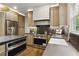 Kitchen featuring stainless steel appliances, stone countertops, and custom cabinets at 12230 Asbury Park Dr, Roswell, GA 30075