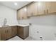 Laundry room with built-in cabinetry, modern countertops, and stainless steel sink at 12230 Asbury Park Dr, Roswell, GA 30075