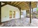 Covered stone patio leading to backyard deck and white exterior of the home at 12230 Asbury Park Dr, Roswell, GA 30075