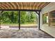 Covered patio with stone floors and view of the lush, green backyard at 12230 Asbury Park Dr, Roswell, GA 30075